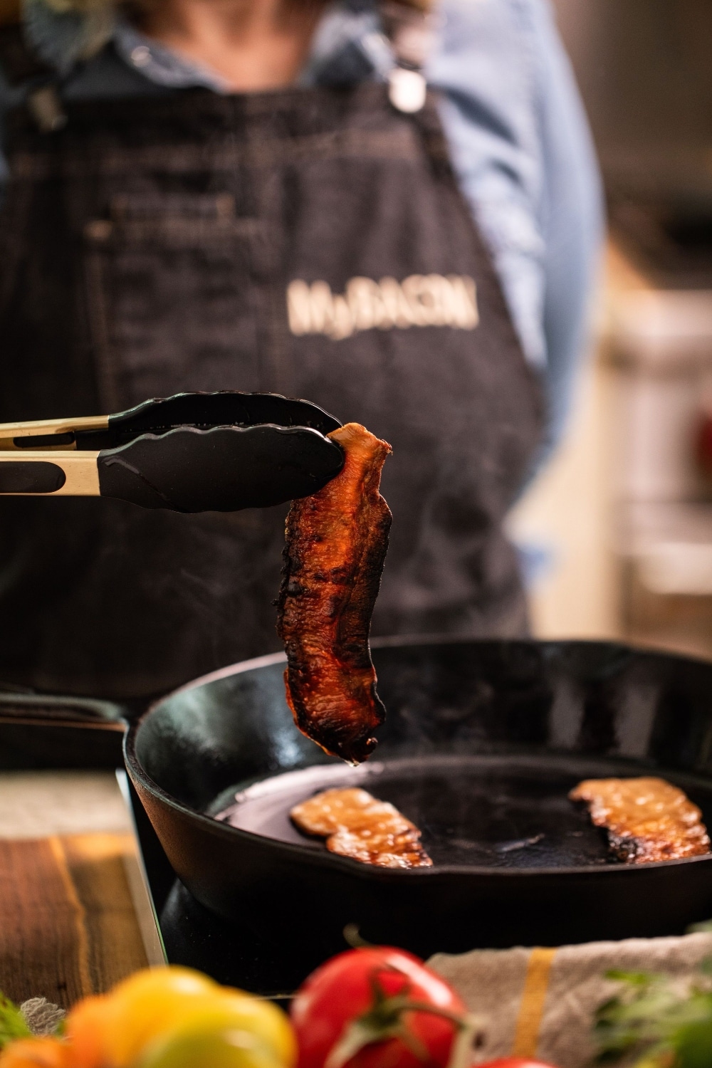holding bacon over pan